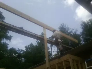 Carpenter setting a ridge beam over a new addition frame — Ice Dam Removal by Roofing Brothers in Bryn Mawr