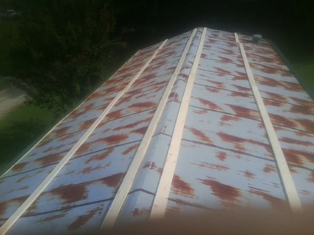 Rusted metal roof panels with new wood purlins before replacement — Storm Damage Roof Repair in Bryn Mawr by Roofing Brothers