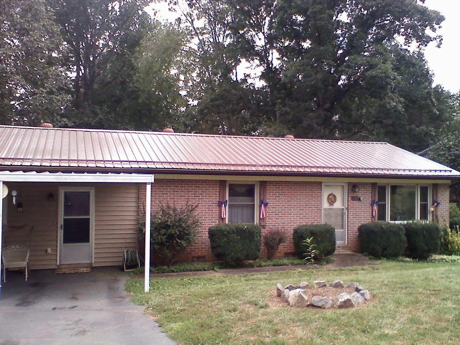 Bronze metal roof and carport on a brick ranch home — Roof Repair work by our crew in Bryn Mawr